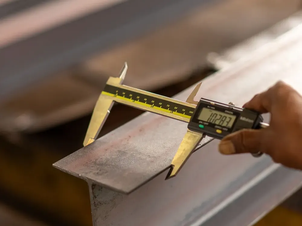Precision caliper measuring a mechanical component, representing rigorous engineering measurement and analysis